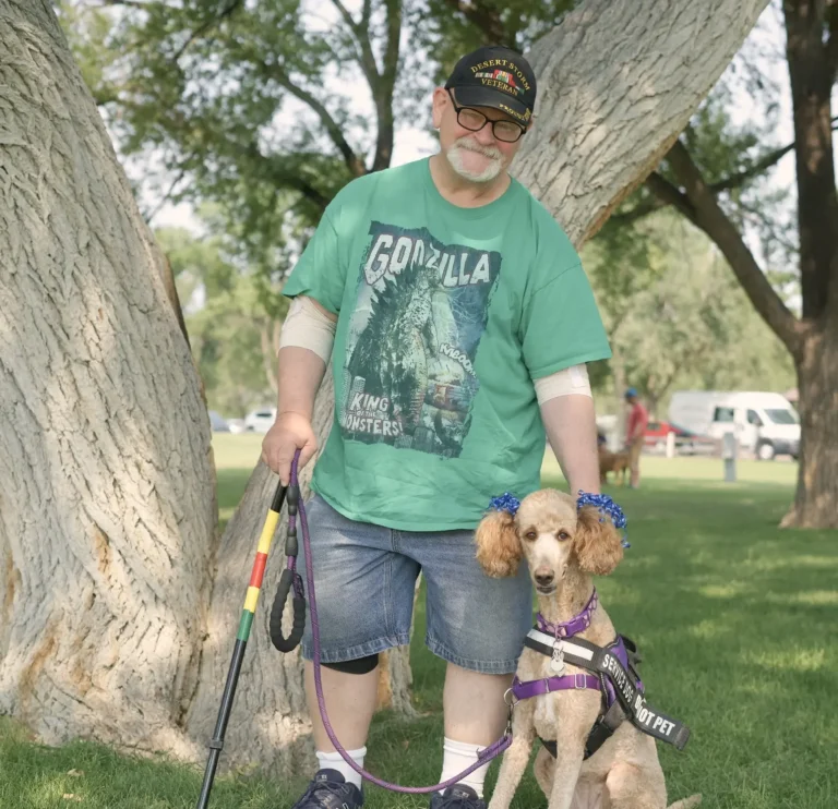 Home a person with a cane standing with a service dog